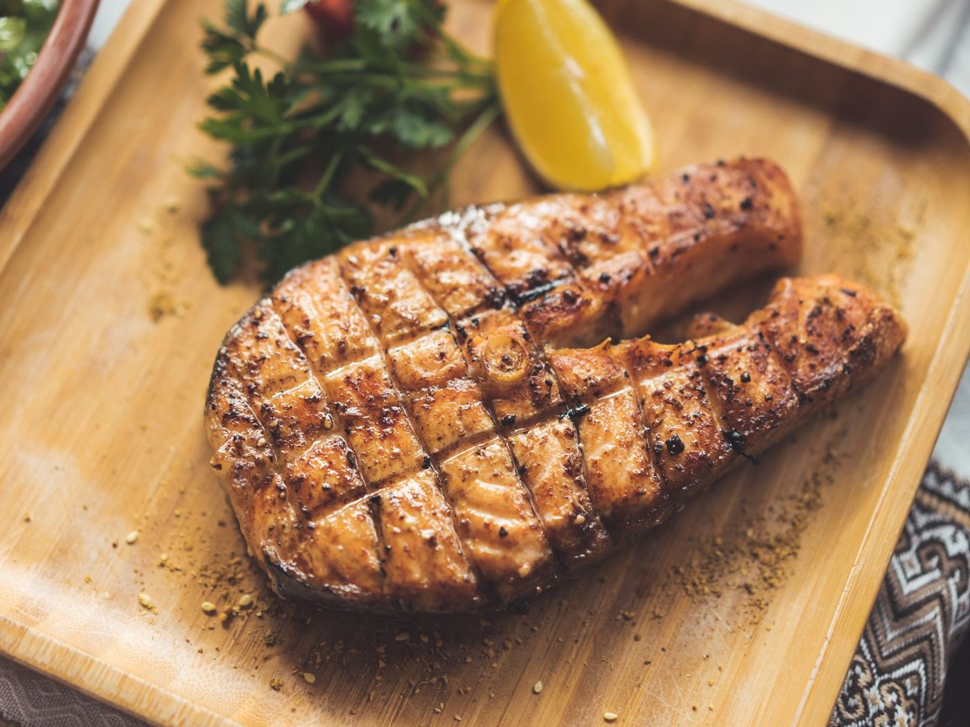 Grilled salmon steak crusted with cracked black pepper and lemon